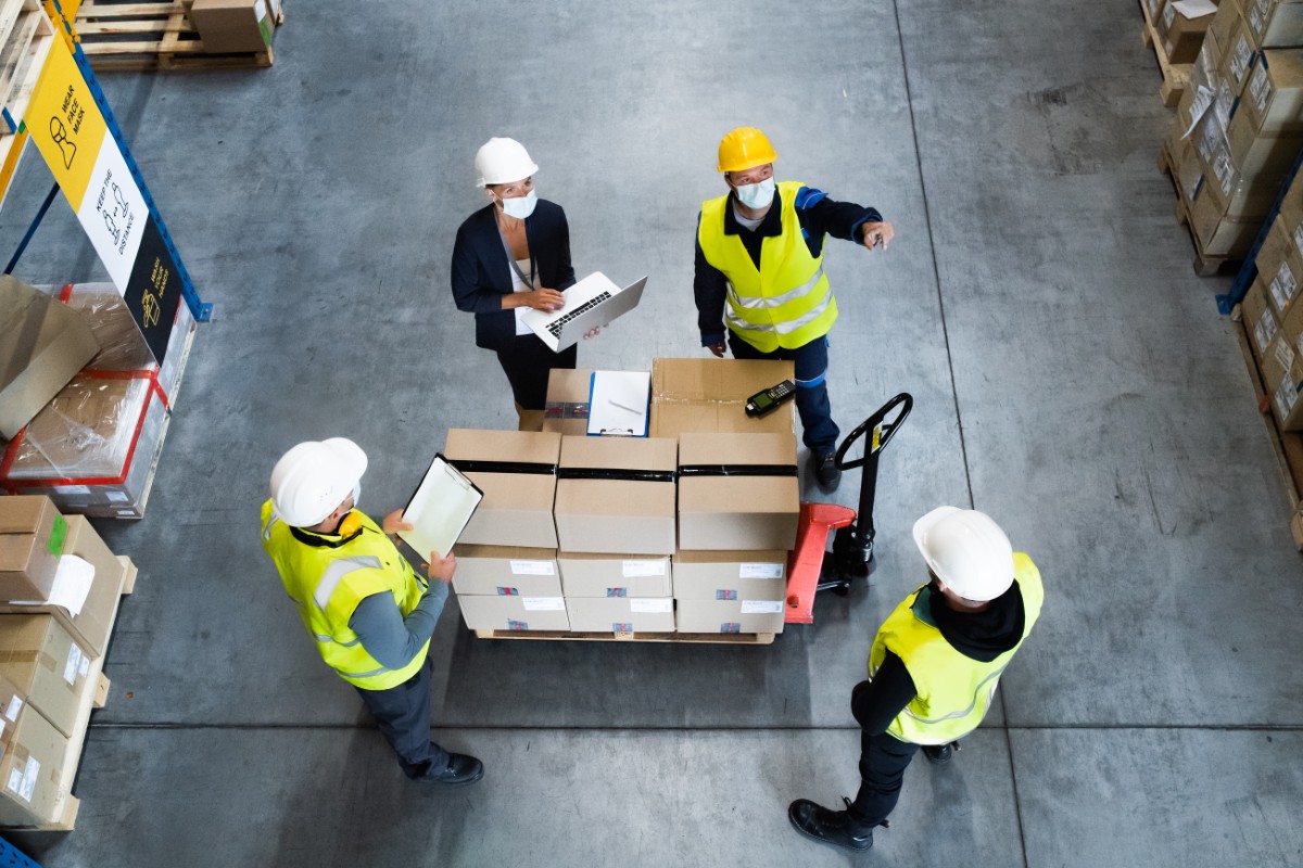 A logistics professional planning multi-location freight shipping in Los Angeles, CA, with maps and shipping documents.